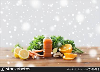healthy eating, food, diet and vegetarian concept - bottle with carrot juice, fruits and vegetables on wooden table over snow. bottle with carrot juice, fruits and vegetables