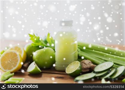 healthy eating, food, diet and vegetarian concept - bottle with green juice, fruits and vegetables on wooden table over snow. bottle with green juice, fruits and vegetables