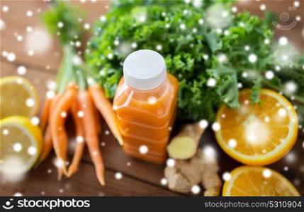 healthy eating, food, diet and vegetarian concept - close up of bottle with carrot juice, fruits and vegetables on wooden table over snow. bottle with carrot juice, fruits and vegetables