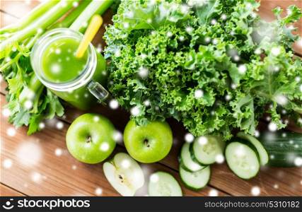 healthy eating, food, diet and vegetarian concept - close up of glass jug with green juice, fruits and vegetables on wooden table over snow. close up of jug with green juice and vegetables