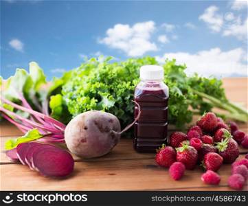 healthy eating, food, dieting and vegetarian concept - bottle with beetroot juice, fruits and vegetables on wooden table over blue sky background