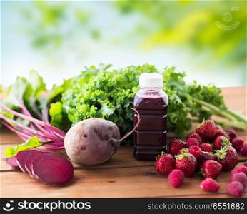 healthy eating, food, dieting and vegetarian concept - bottle with beetroot juice, fruits and vegetables on wooden table over green natural background. bottle with beetroot juice, fruits and vegetables. bottle with beetroot juice, fruits and vegetables