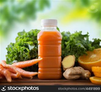 healthy eating, food, dieting and vegetarian concept - bottle with carrot juice, fruits and vegetables on wooden table over green natural background. bottle with carrot juice, fruits and vegetables. bottle with carrot juice, fruits and vegetables