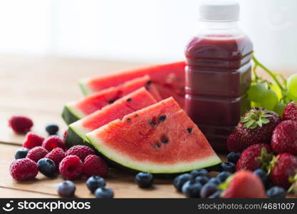 healthy eating, food, dieting and vegetarian concept - bottle with fruit and berry juice or smoothie on wooden table