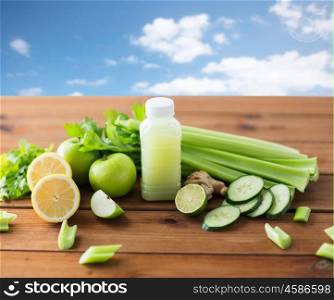 healthy eating, food, dieting and vegetarian concept - bottle with green juice, fruits and vegetables on wooden table over blue sky background