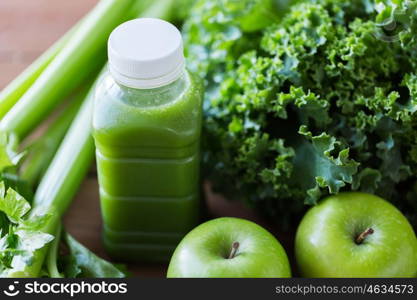 healthy eating, food, dieting and vegetarian concept - bottle with green juice, fruits and vegetables on wooden table