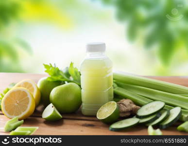 healthy eating, food, dieting and vegetarian concept - bottle with green juice, fruits and vegetables on wooden table over green natural background. close up of bottle with green juice and vegetables. close up of bottle with green juice and vegetables