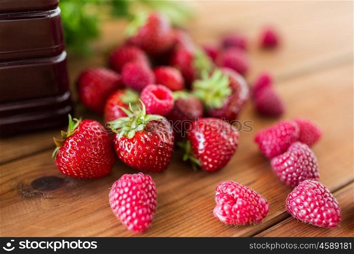 healthy eating, food, dieting and vegetarian concept - bottle with juice and berries on wooden table