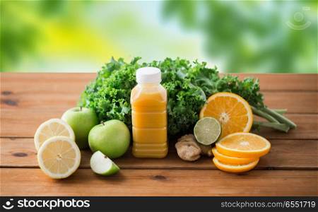 healthy eating, food, dieting and vegetarian concept - bottle with orange juice, fruits and vegetables on wooden table over green natural background. bottle with orange juice, fruits and vegetables. bottle with orange juice, fruits and vegetables