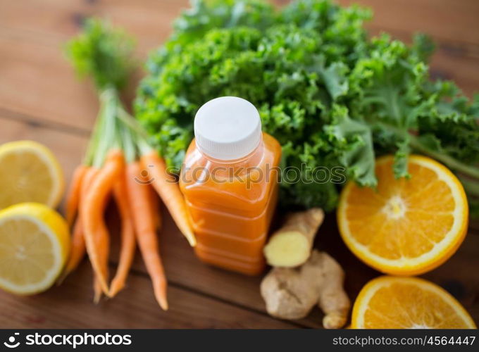 healthy eating, food, dieting and vegetarian concept - close up of bottle with carrot juice, fruits and vegetables on wooden table