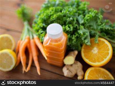 healthy eating, food, dieting and vegetarian concept - close up of bottle with carrot juice, fruits and vegetables on wooden table