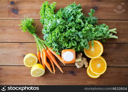 healthy eating, food, dieting and vegetarian concept - close up of bottle with carrot juice, fruits and vegetables on wooden table