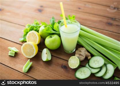 healthy eating, food, dieting and vegetarian concept - close up of glass with green juice, fruits and vegetables on wooden table