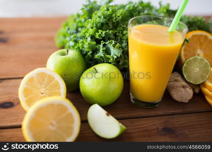 healthy eating, food, dieting and vegetarian concept - close up of glass with orange juice, fruits and vegetables on wooden table