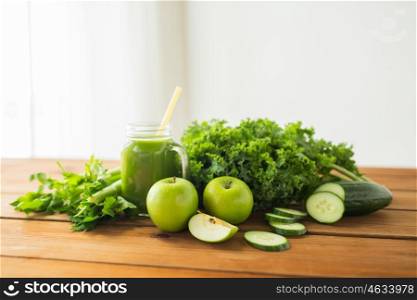 healthy eating, food, dieting and vegetarian concept - close up of glass jug with green juice, fruits and vegetables on wooden table