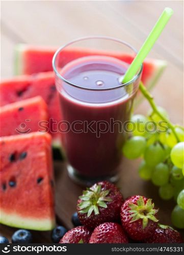 healthy eating, food, dieting and vegetarian concept - close up of glass with fruit and berry juice or smoothie on wooden table