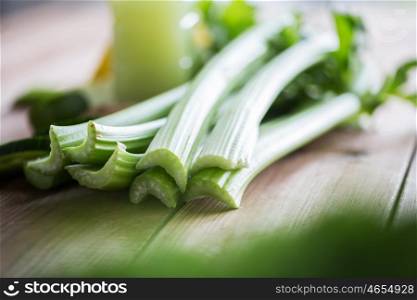 healthy eating, food, dieting and vegetarian concept - close up of green celery stems on wood