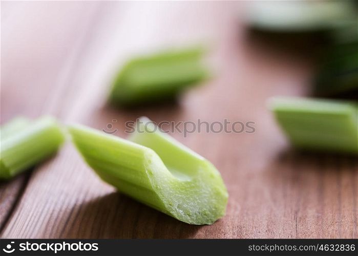 healthy eating, food, dieting and vegetarian concept - close up of sliced celery stem on wood