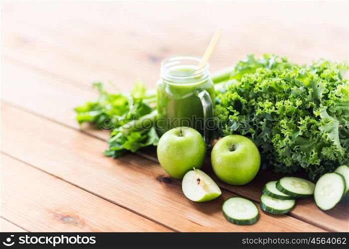 healthy eating, food, dieting and vegetarian concept - glass jug with green juice, fruits and vegetables on wooden table
