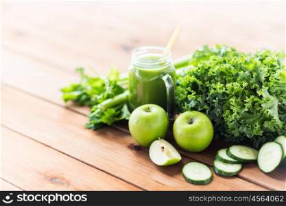 healthy eating, food, dieting and vegetarian concept - glass jug with green juice, fruits and vegetables on wooden table