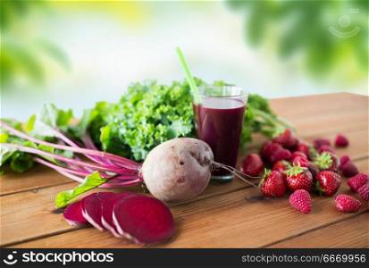 healthy eating, food, dieting and vegetarian concept - glass of beetroot juice, fruits and vegetables on wooden table over green natural background. glass of beetroot juice, fruits and vegetables. glass of beetroot juice, fruits and vegetables