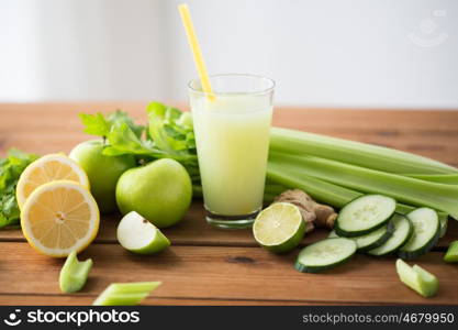 healthy eating, food, dieting and vegetarian concept - glass of green juice with fruits and vegetables on wooden table