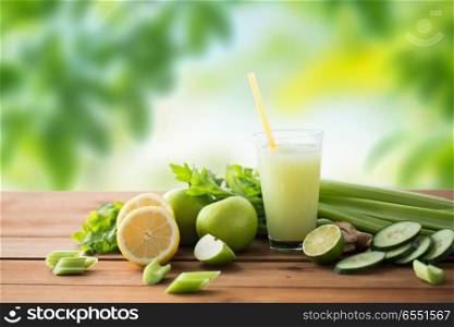 healthy eating, food, dieting and vegetarian concept - glass of green juice with fruits and vegetables on wooden table over green natural background. glass of green juice with fruits and vegetables. glass of green juice with fruits and vegetables