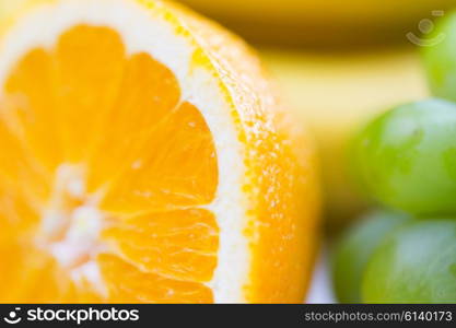 healthy eating, food, fruits and diet concept - close up of fresh juicy orange and grape