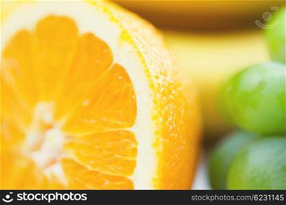 healthy eating, food, fruits and diet concept - close up of fresh juicy orange and grape