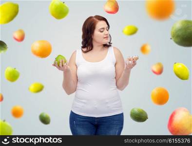 healthy eating, junk food, diet and choice people concept - plus size woman choosing between apple and cookie over gray background with fruits