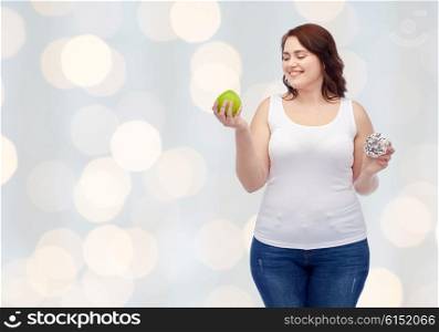 healthy eating, junk food, diet and choice people concept - smiling plus size woman choosing between apple and donut over holidays lights background