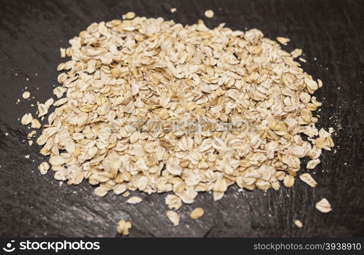 Healthy eating oat flakes closeup on a stone background. Healthy eating oat flakes closeup on a stone background.