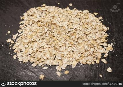 Healthy eating oat flakes closeup on a stone background. Healthy eating oat flakes closeup on a stone background.