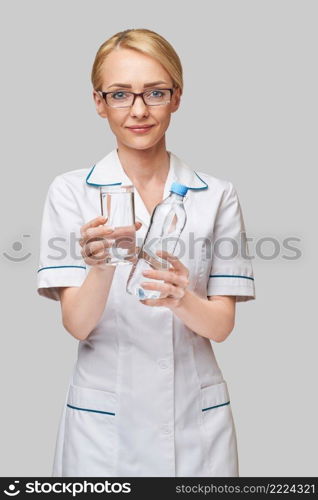 Healthy eating or lifestyle concept - female woman doctor holding and a glass of clear fresh water.. Healthy eating or lifestyle concept - female woman doctor holding and a glass of clear fresh water