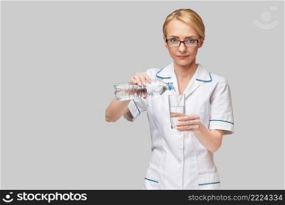 Healthy eating or lifestyle concept - female woman doctor holding and a glass of clear fresh water.. Healthy eating or lifestyle concept - female woman doctor holding and a glass of clear fresh water