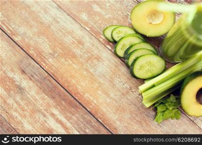 healthy eating, organic food, advertisement and diet concept - close up of fresh green juice glass and vegetables on blank table