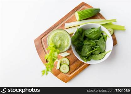 healthy eating, organic food and diet concept - close up of fresh green juice with celery on wooden table