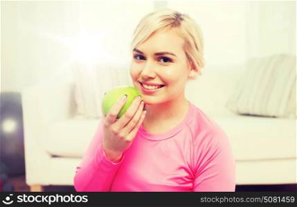 healthy eating, organic food, diet and people concept - happy woman eating apple at home. happy woman eating apple at home