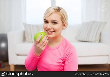 healthy eating, organic food, diet and people concept - happy woman eating apple at home