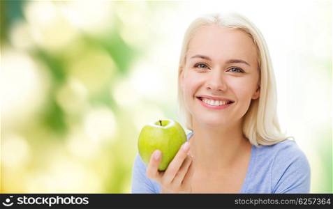 healthy eating, organic food, fruits, diet and people concept - happy woman eating green apple over green natural background