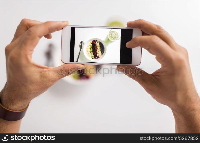 healthy eating, people and technology concept - hands photographing breakfast by smartphone. man photographing healthy breakfast by smartphone