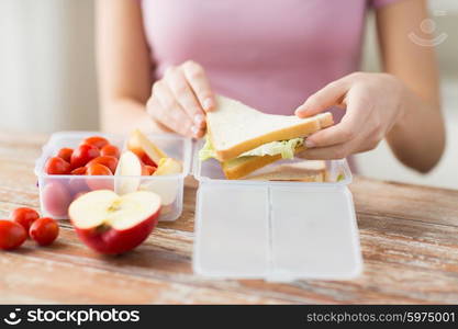 healthy eating, storage, dieting and people concept - close up of woman with food in plastic container at home kitchen