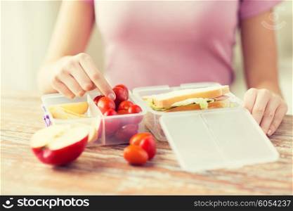 healthy eating, storage, dieting and people concept - close up of woman with food in plastic container at home kitchen