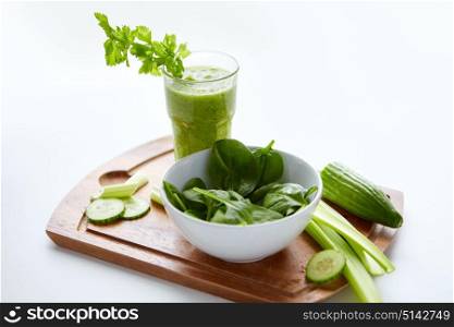 healthy eating, vegetarian food and diet concept - close up of glass with green juice, fruits and vegetables on table. close up of glass with green juice and vegetables