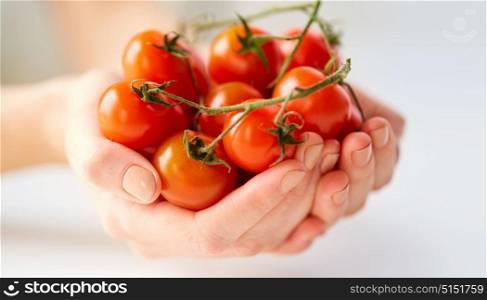 healthy eating, vegetarian food and people concept - close up of female hands holding cherry tomatoes. close up of female hands holding cherry tomatoes