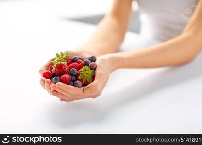 healthy eating, vegetarian food and people concept - close up of young woman hands holding berries. close up of young woman hands holding berries