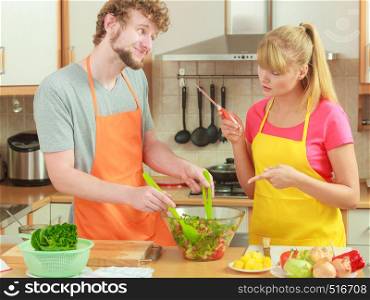 Healthy eating, vegetarian food, cooking, dieting and people concept. Couple in kitchen at home preparing meal mixing fresh vegetables salad
