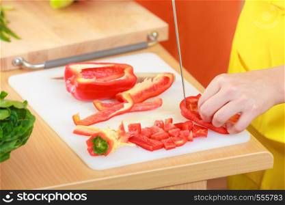 Healthy eating, vegetarian food, cooking, dieting and people concept. Woman in kitchen at home preparing fresh salad slicing vegetable red pepper closeup