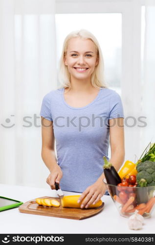 healthy eating, vegetarian food, cooking , dieting and people concept - smiling young woman chopping vegetables at home