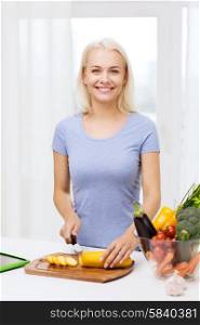 healthy eating, vegetarian food, cooking , dieting and people concept - smiling young woman chopping vegetables at home